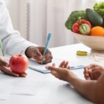 Dietician,African,Woman,Giving,Young,Patient,Healthy,Diet,Tips,,Holding